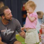 little kickers coach teaching young girl