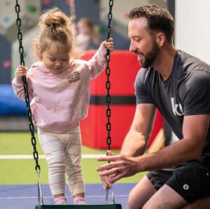 little girl on swing at kids gym